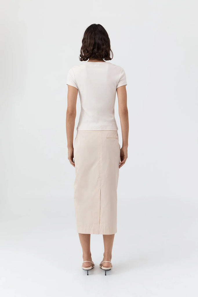 Person wearing a white top and beige skirt on a white background