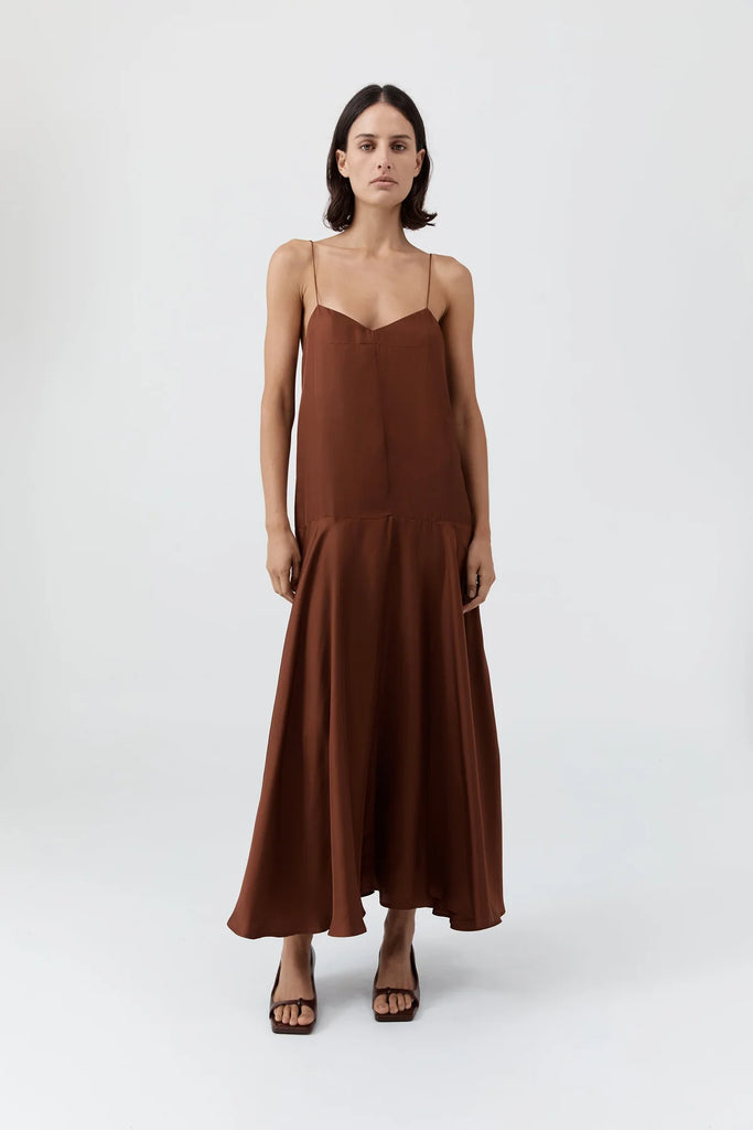 Woman wearing a brown slip dress on a white background
