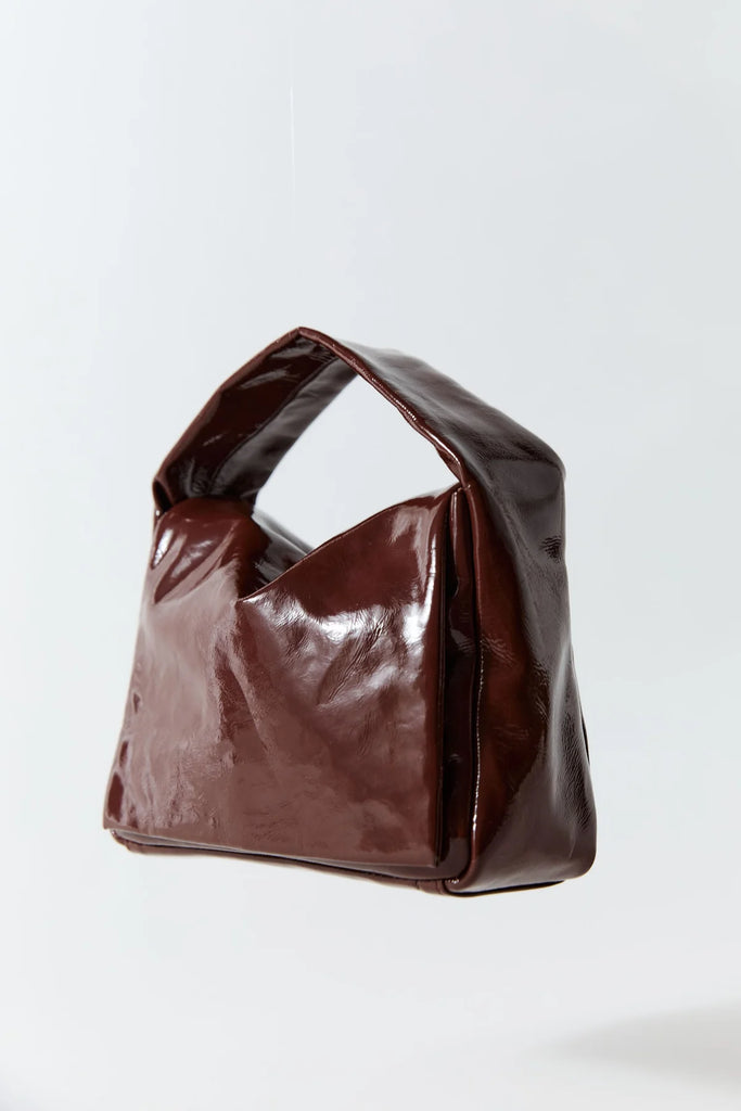 Brown leather handbag on a light gray background
