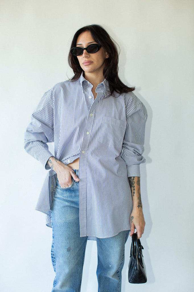 Woman wearing a striped shirt and jeans against a white background