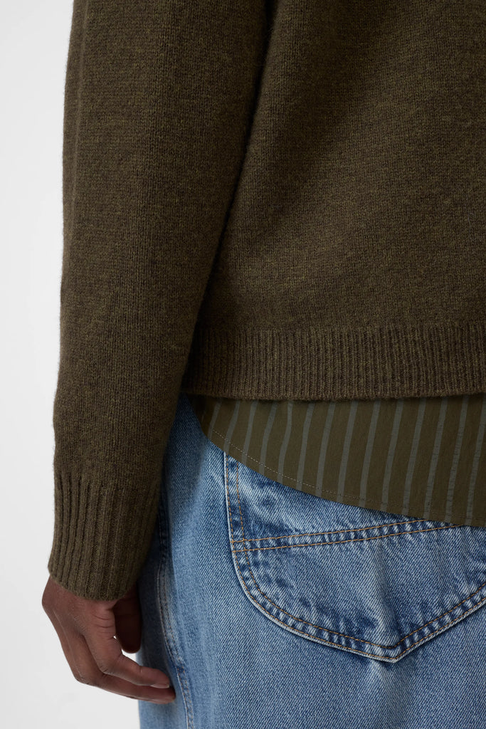 Brown sweater with a striped pattern over a white background