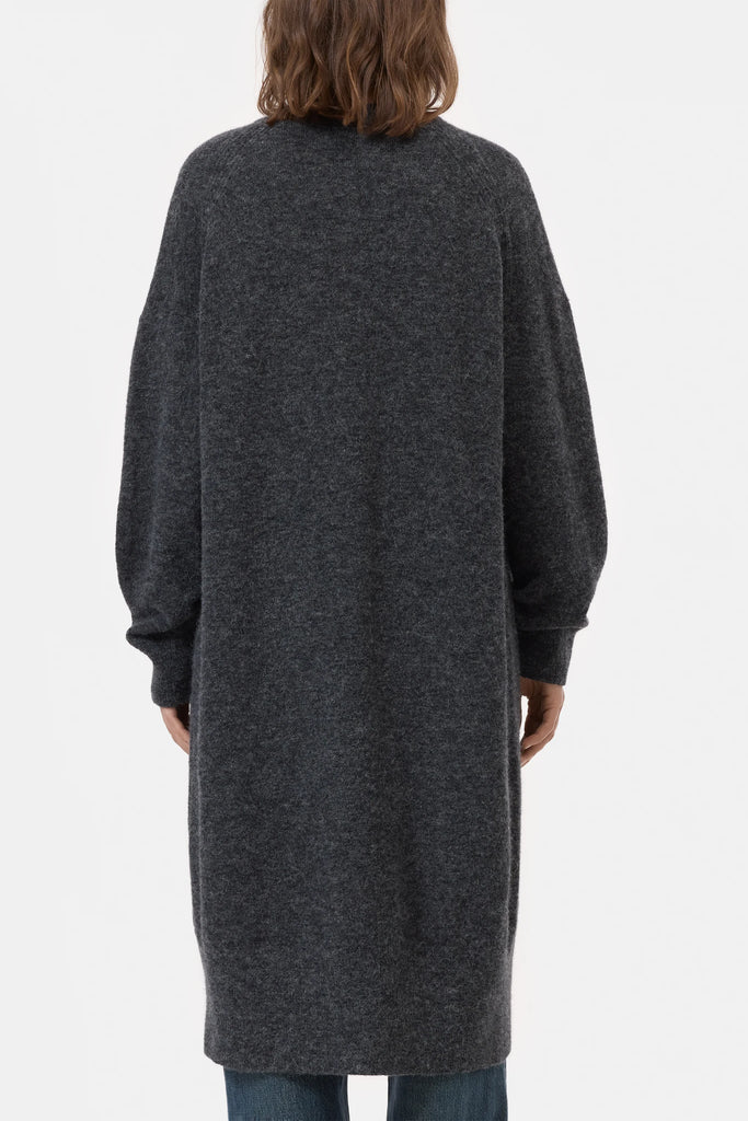 Person wearing a long dark gray cardigan on a white background