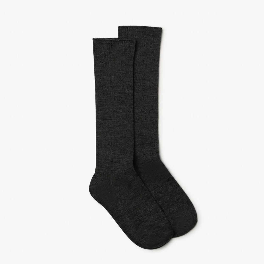 Pair of dark gray knee-high socks on a light gray background