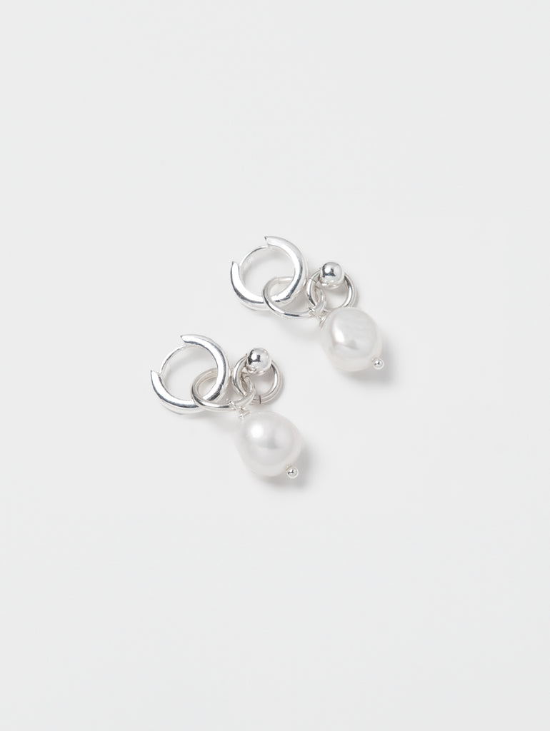 Pair of silver earrings with pearls on a white background