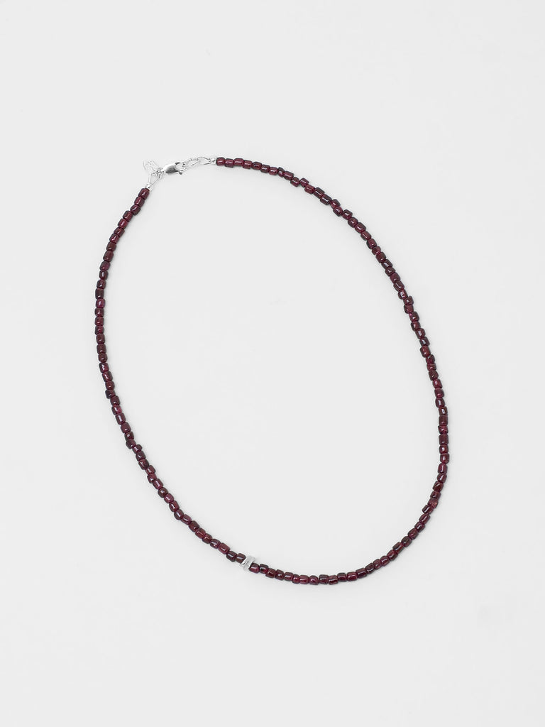 Black beaded necklace on a light gray background