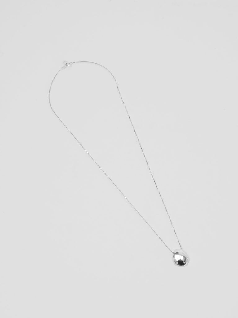 Silver necklace with a small pendant on a light gray background